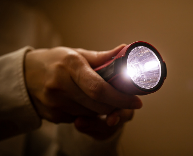 Woman looks at water on a store shelf.