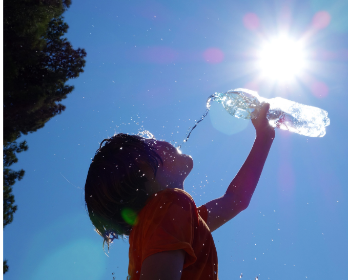 Child drinking water with the sun shining down